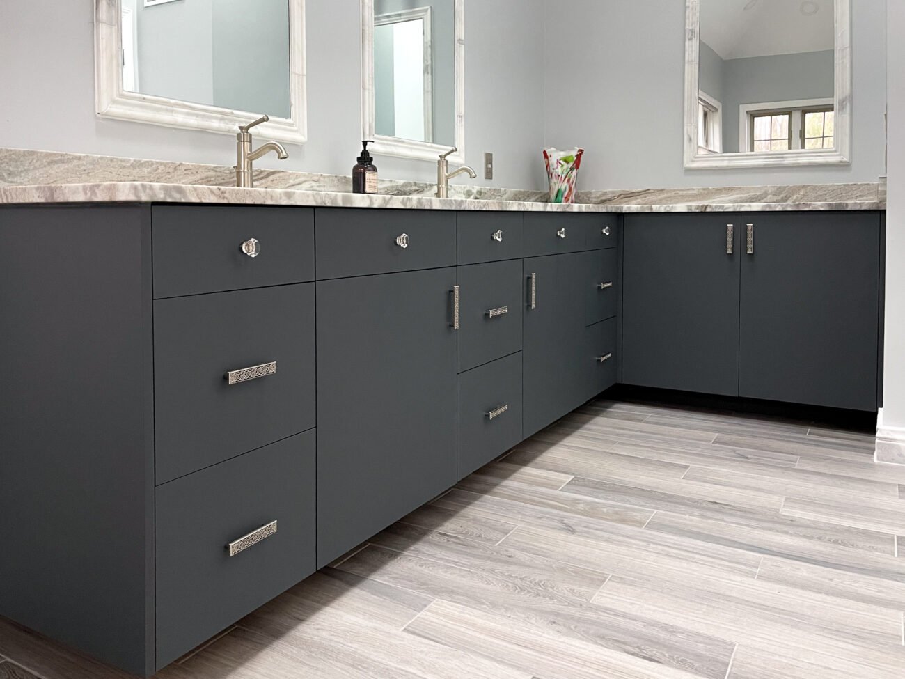 L-shaped vanity with carbon grey frameless cabinets with slab doors and drawer fronts